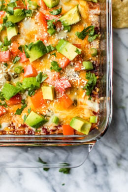 Grab some chips and dig into this cheesy, hot Mexican Layer Dip made with spiced ground turkey, refried beans, salsa, green chilies, tomatoes, cheese and avocado.