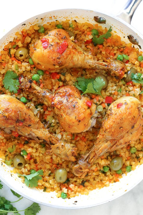 Skillet Cauliflower "Arroz" Con Pollo (Spanish chicken and rice) uses cauliflower rice as a low-carb swap, which means larger portions with 85% less calories than rice!